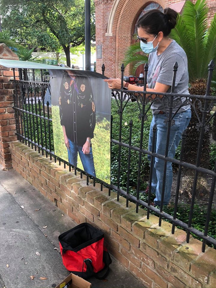 A volunteer removes a damaged metal print.